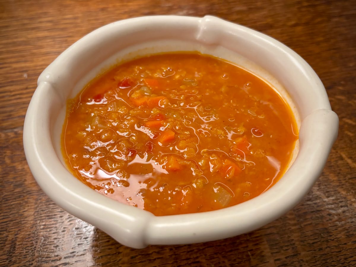 A bowl of red lentil tomato soup.
