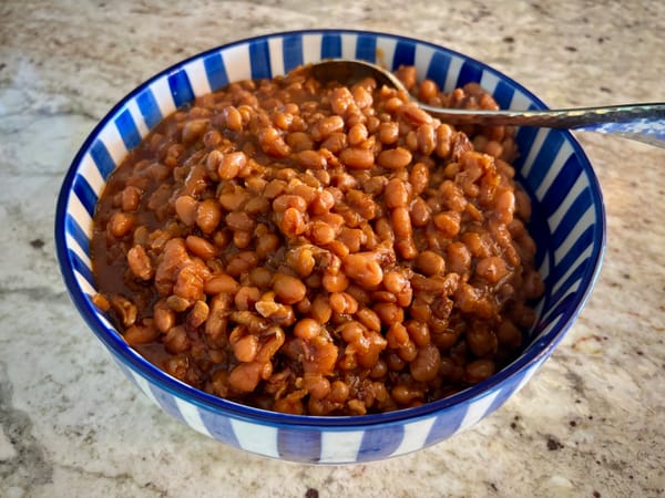 A blue and white ceramic bowl filled with baked beans
