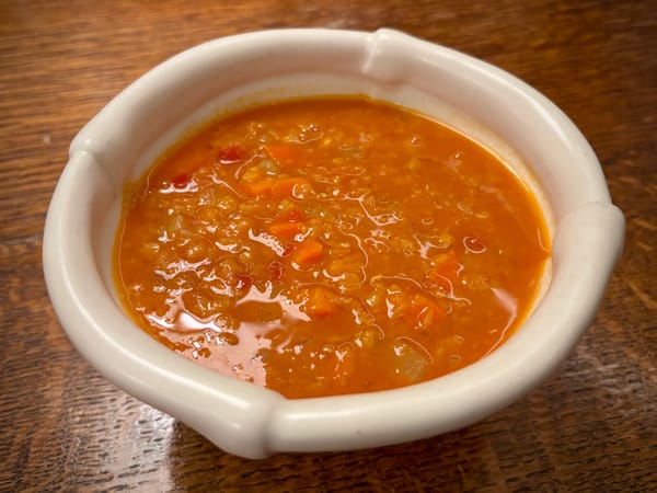 A bowl of red lentil tomato soup.